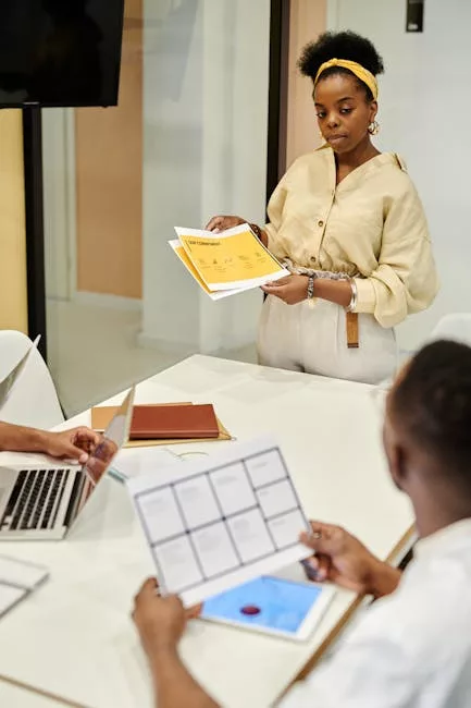 A diverse team collaborates in a modern office meeting, discussing documents and presentations.