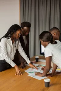 A diverse group of professionals engaged in a brainstorming session around a work table.