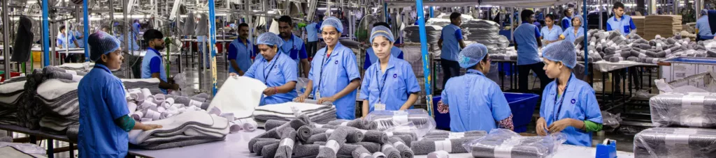 Indian textile factory workers expertly packaging products on an assembly line.