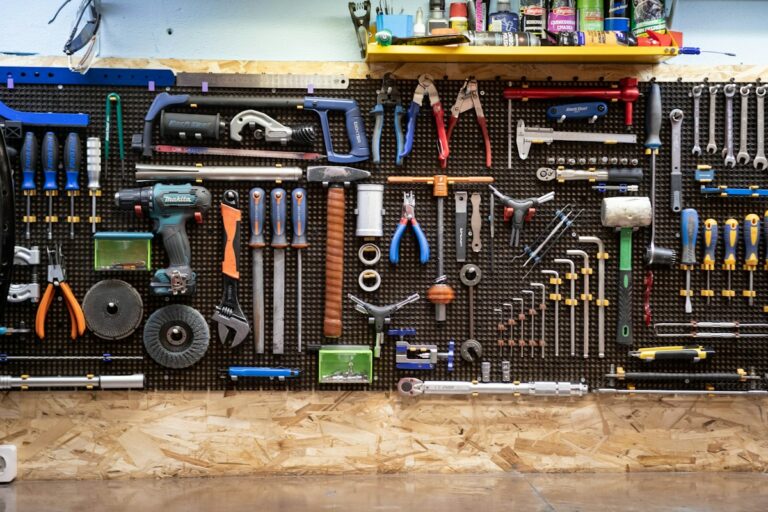 Mur d’outils suspendus dans un atelier de mécanique : clés, tournevis, pinces et scies