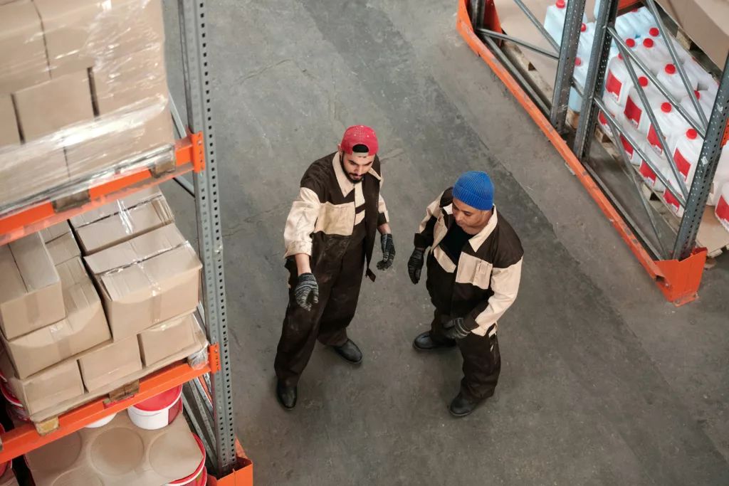 Deux collègues échangeant dans un entrepôt logistique